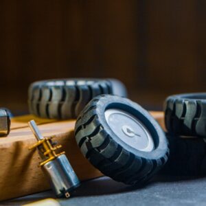 Detailed view of robotic wheels and motors on a workshop table, showcasing components for building robotics projects.